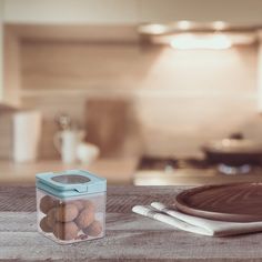 a glass jar filled with eggs sitting on top of a wooden table next to a cutting board