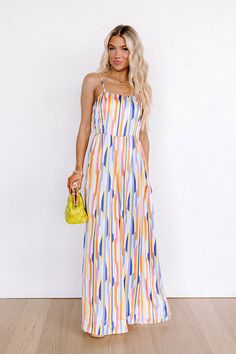 - Step into a world of vibrant style with this trendy wide-leg jumpsuit featuring a mesmerizing colorful print. Its sleek satin finish makes a glamorous statement whether you are dancing under the city lights or lounging in luxury. - Lightweight material with an abstract print featuring orange, yellow, blue, ivory, and pink hues and a satin finish - A square cut neckline - Adjustable spaghetti straps - An open back with a tie detail - A waistline with an elastic back - A relaxed silhouette that Vibrant Blue Maxi Dress For Party, Trendy Multicolor Maxi Dress For Night Out, Vibrant Blue Party Maxi Dress, Colorful Pattern Maxi Dress For Party, Multicolor Maxi Jumpsuits And Rompers For Summer, Summer Vacation Satin Maxi Dress, Summer Satin Maxi Dress For Vacation, Beach Multicolor Maxi Jumpsuits And Rompers, Spring Multicolor Print Jumpsuits And Rompers