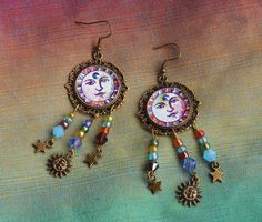 "Bohemian earrings with colorful personality featuring a vintage sun face pendant with painted accents and a bunch of vibrant glass beads! Little star and sun charms swing beneath adding even more celestial style and a quality \"S\" rhinestone shimmers from the sun's third eye! And they are lightweight, too, so no annoying pulling on your ears as they sway...Celestial cuteness! Antiqued Gold-plated Earwires, Antiqued Gold-plated Pendants, 1\" round, drop 2 1/2\" MANY ARTFUL ITEMS ARE AVAILABLE I Boho Sun, My Best Friend's Birthday, Sun Face, Hand Painted Jewelry, Face Earrings, Tassel Jewelry, Bohemian Rings, Saint James, Hippie Jewelry