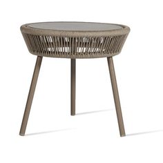 the round table is made out of wicker and has a glass top with wooden legs