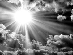 the sun shines brightly through clouds in this black and white photo