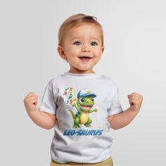 Celebrate your little dinosaur fan's special day with this adorable personalized T-shirt. 👕 Design: This lovingly printed T-shirt features two playful and funny dinosaur, perfect for young dino enthusiasts. 🧒 Personalized: Make it even more special by adding your child's name and age, creating a unique birthday shirt just for them. 📏 Sizes: Available in various children's sizes, so you can find the perfect fit. Check our profile picture for a size measurement chart. 🌈 Color: The T-shirt is a Playful White Dinosaur Print Top, Birthday Dinosaur Print Short Sleeve T-shirt, Birthday T-shirt With Dinosaur Print, Dinosaur Print Short Sleeve T-shirt For Birthday, White T-shirt With Dinosaur Print For Birthday, Playful Dinosaur Print Crew Neck T-shirt, First Birthday T-shirt With Dinosaur Print, Dinosaur Print Short Sleeve T-shirt For First Birthday, Crew Neck T-shirt With Dinosaur Print For First Birthday