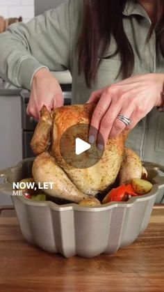 a woman is preparing a turkey in a roasting pan