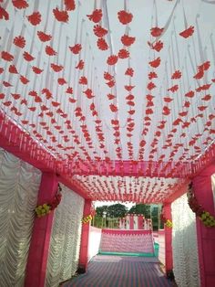 an aisle decorated with red flowers and white draping for a wedding or special event