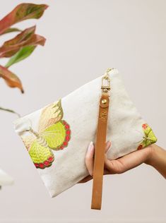 The embroidered butterflies are set into undyed woven linen, lined with a bittersweet berries on wicker print and finished with a leather wristlet strap.  This print will go everywhere this summer. These purses are the perfect size for a cell phone, wallet, lipstick and your other everyday essentials. The sturdy brass Spring Rectangular Wristlet With Wrist Strap, Spring Floral Embroidered Clutch, Butterfly Clutch, Butterfly Handbags, Pink Floral Embroidered Clutch Bag, Cozy Candles, Embroidered Butterfly, Rose Shop, Eco Gifts