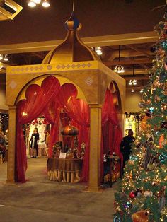 a christmas tree is in the middle of a room with red drapes on it