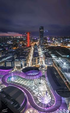 an aerial view of a city at night with lots of lights and buildings in the background