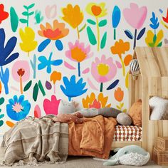 a child's bedroom with colorful flowers painted on the wall and bed in front