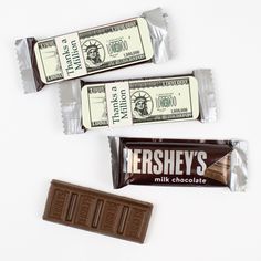 three bars of hershey's milk chocolate on a white surface with one bar in the middle