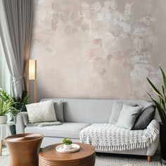 a living room filled with furniture next to a wall covered in pink and white flowers