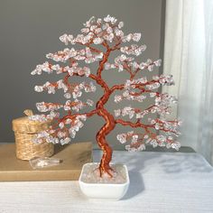 a wire tree sculpture sitting on top of a table