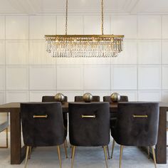 a dining room table with four chairs and a chandelier