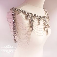 a white mannequin with lots of chains attached to it's neckline