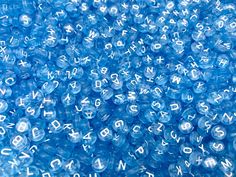 blue beads with white letters and numbers are shown in close up view on the surface