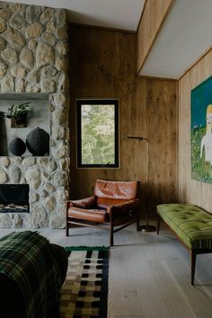 a living room filled with furniture and a painting on the wall next to a fire place