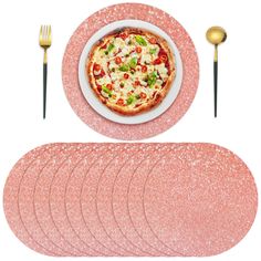 there is a plate with pizza on it next to six placemats and forks