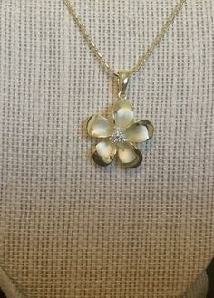 .925 Sterling silver with 14K Yellow Gold overlay Hawaiian Plumeria Pua Melia 3-stone Past, Present and Future Necklace. Designed to mimic the look of fine jewelry at a fraction of the cost. -- The size is 22MM, a bit under quarter size. FREE Italian Sterling Silver beaded chain included your choice of length. It has a Sandblasted Matte center with High-Polished shiny edges and three Cubic zirconias in the Flowers center for added sparkle. -- The Plumeria is sacred in Hawaiian culture and is oft Delicate Engraved White Gold Jewelry, Fine Jewelry Flower Pendant With Polished Finish, Fine Jewelry White Gold Flower Pendant, Formal Jewelry With Polished Flower Pendant, Dainty Diamond Cut Flower Pendant Jewelry, Formal Flower Pendant Jewelry With Polished Finish, Formal Polished Flower Pendant Jewelry, Exquisite White Polished Jewelry, Gold Sterling Silver Flower Pendant Jewelry