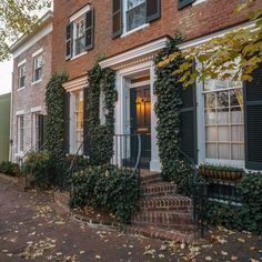 an old brick building with ivy growing on it's windows and shutters in front