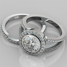 This classic Agape Wedding Set features an engagement ring with a Split V design that allows in more light to create a dazzling spectacle of sparkling colors enhancing the stunning bezel mounted gemstone that is surrounded by a halo of shimmering pav stones.  Made to your specifications of precious metal, the engagement ring has a 2.0Ct Round Cut Simulated Diamond Center Stone and .63Ct in Side Stones. The Contoured Matching Band comes with an additional .26Ct in Side Stones. (Total Carat Weight Split Shank With Wedding Band, Split Shank Engagement Ring With Band Bridal Sets, Split Shank Halo Ring With Wedding Band, Split Shank Engagement Ring Round, Halo Split Shank Engagement Ring, Luxury Jewelry Store, Round Cut Engagement Ring, V Design, Bridal Consultant