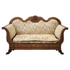 an old fashioned wooden couch with floral upholstered fabric