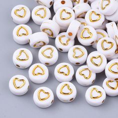 white and gold heart shaped beads on grey background