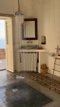 a bathroom with a shower head, sink and mirror on the wall next to an open door