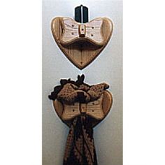 two wooden wall hangings that have been made to look like people with hats and scarves