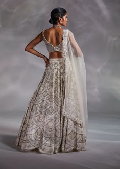 Editor's Note Featuring an off-white hand-embellished blouse, lehenga and solid dupatta with embroidered border Color: Off-white Fabric: Crushed organza, silk and organza Fit type: Blouse: fitted Neckline: V-neckline Components: Lehenga, blouse and dupatta Occasion: Wedding Care: Dry Clean Only About the Designer The crux and essence of the label, Divya Aggarwal, is to challenge and revamp the face of ordinary traditional wear while being customer oriented. Driven by the values of individuality White Cutdana Set For Reception, White Bollywood Sleeveless Lehenga, White Bollywood Lehenga, White Sleeveless Bollywood Lehenga, Festive Sleeveless White Lehenga, Festive White Sleeveless Lehenga, White Organza Pre-draped Saree With Unstitched Blouse, White Sleeveless Gown For Festive Occasions, White Sleeveless Festive Gown