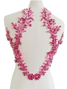 the back of a mannequin with pink flowers on it's neckline