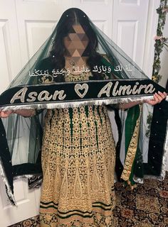 a woman is holding up a sign that says asan al amira on it