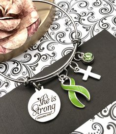 This listing is for a beautiful, handmade, lime green ribbon bracelet. Please contact me if you need a different ribbon color. * The 1-inch pendant is laser cut, silver, and reads: She is Strong / Proverbs 34:25 * Cause ribbon charm is sterling silver plate and acrylic. It measures an inch tall. * Also included is a small, silver plated encouragement charm of your choice. * Swarovski crystal charm to compliment your ribbon. * The silver bangle bracelet is adjustable in size by squeezing or stret Personalized Green Bracelets As Gifts, Customizable Green Bracelet Jewelry, Green Nickel-free Jewelry For Mother's Day, Green Nickel-free Bracelets For Gifts, Green Charms Jewelry For Friendship, Friendship Green Jewelry With Charms, Personalized Green Jewelry For Friendship, Personalized Adjustable Green Jewelry, Personalized Green Bracelets For Mother's Day