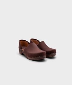 Introducing Brett Low - the perfect blend of style and comfort. This closed-back clog features a low heel and open side detail that is both timeless and unique. Slip into these elegant shoes for an elevated look that won't compromise on comfort. Clog measurements:Heel height: 1 3/4 (4.45 cm)Toe height:̴ 1 5/8 (4.1 cm)Fit:RegularLeather:Nubuck leatherClogs consist of:Base: European Lime WoodSole: Rubber soleFastening: Staples Cork Sandals, Wooden Clogs, Clog Sandals, Elegant Shoes, Boot Shop, Low Heels, Fudge, Clogs, Heel Height