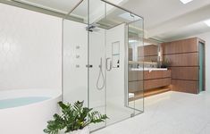 a bathroom with a tub, sink and shower stall in it's center area