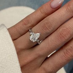 a woman's hand with a diamond ring on it