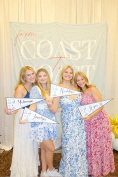 three women in dresses are holding signs that say coast to coast, and one is wearing a blue dress