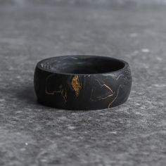 The Grand Prix is a forged black carbon fiber wedding ring crafted with formula-one grade 24,000 carbon fiber tow - pressurized with gold leaf flake, giving it a signature "marbled" aesthetic. Each carbon fiber ring is going to have a unique pattern, so every ring will be truly one-of-a-kind. If you're looking for a wedding ring that's exclusive to you, The Grand Prix is the carbon fiber ring to go with. This ring is made exclusively with carbon fiber, which means it's safe for wear by electrici Mens Black Jewelry, Samhain Ceremony, Marble Aesthetics, Fun Rings, Carbon Fiber Ring, Carbon Fiber Rings, Unique Mens Rings, Man Ring, Handmade Gold Jewellery