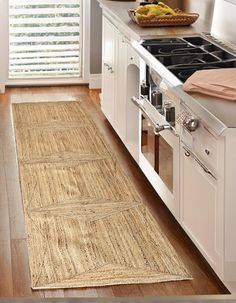 a kitchen with white cabinets and an area rug that looks like it has been made out of