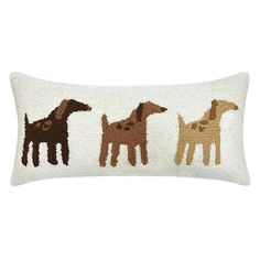 an embroidered pillow with three dogs in different colors and sizes, on a white background