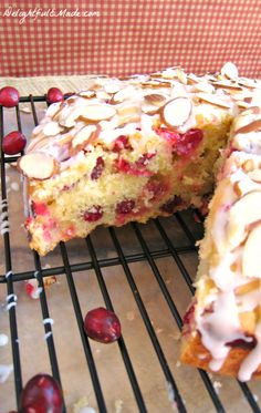 a close up of a cake on a cooling rack with cherries and almonds