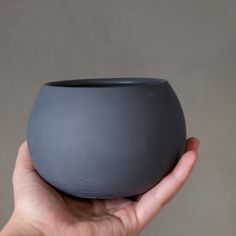 a person holding a gray bowl in their hand