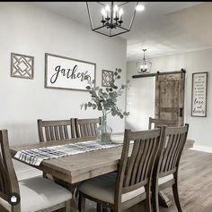 a dining room table with chairs and a vase filled with flowers on top of it