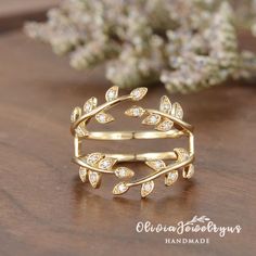 a gold ring with leaves and diamonds on it