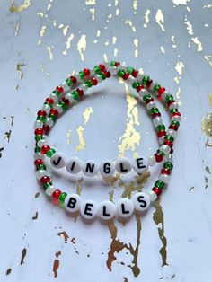 two beaded bracelets with words on them that say,'single bells '