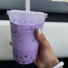 a person holding a purple drink in their hand