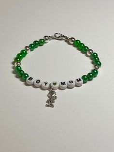 "This is a handmade beaded bracelet for all those boy moms out there!! Very cute green and silver color with words \"Boy Mom\" and a cute little boy accent charm on a stretchy elastic with clasp. Would fit a 7\" wrist or bigger easily.   The silver beads really make the charm shine! Picture taken in different lighting to show how it looks under different settings. We offer free shipping on all of our items! If you are interested in a certain color combination, please send me a private message to Green 8mm Beads Bracelets As Gift, Casual Letter Beads Stretch Bracelet For Mother's Day, Casual Personalized Jewelry For Mother's Day, Green Stretch Bracelet With 8mm Beads As Gift, Casual Stretch Bracelet With Round Beads For Mother's Day, Casual Round Beads Stretch Bracelet For Mother's Day, Casual Beaded Stretch Bracelet For Mother's Day, Green Letter Beads Jewelry For Birthday, Green Bracelets For May Birthstone Birthday