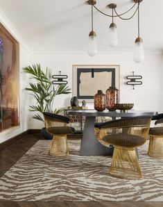 a modern dining room with an oval table and chairs in the center, surrounded by zebra print rugs