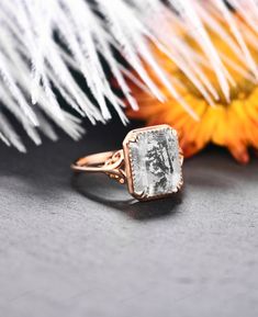 a close up of a ring with a flower in the background