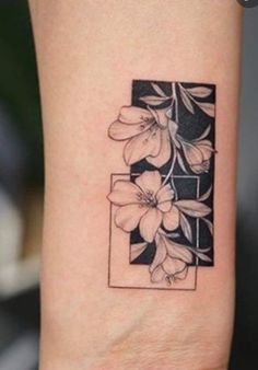 a tattoo with flowers on the wrist and an image of a square in the middle