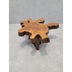 a piece of wood that is shaped like a snowflake or tree stump, sitting on concrete