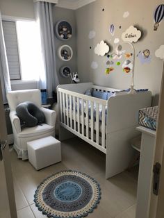 a baby's room with a crib, chair and rug